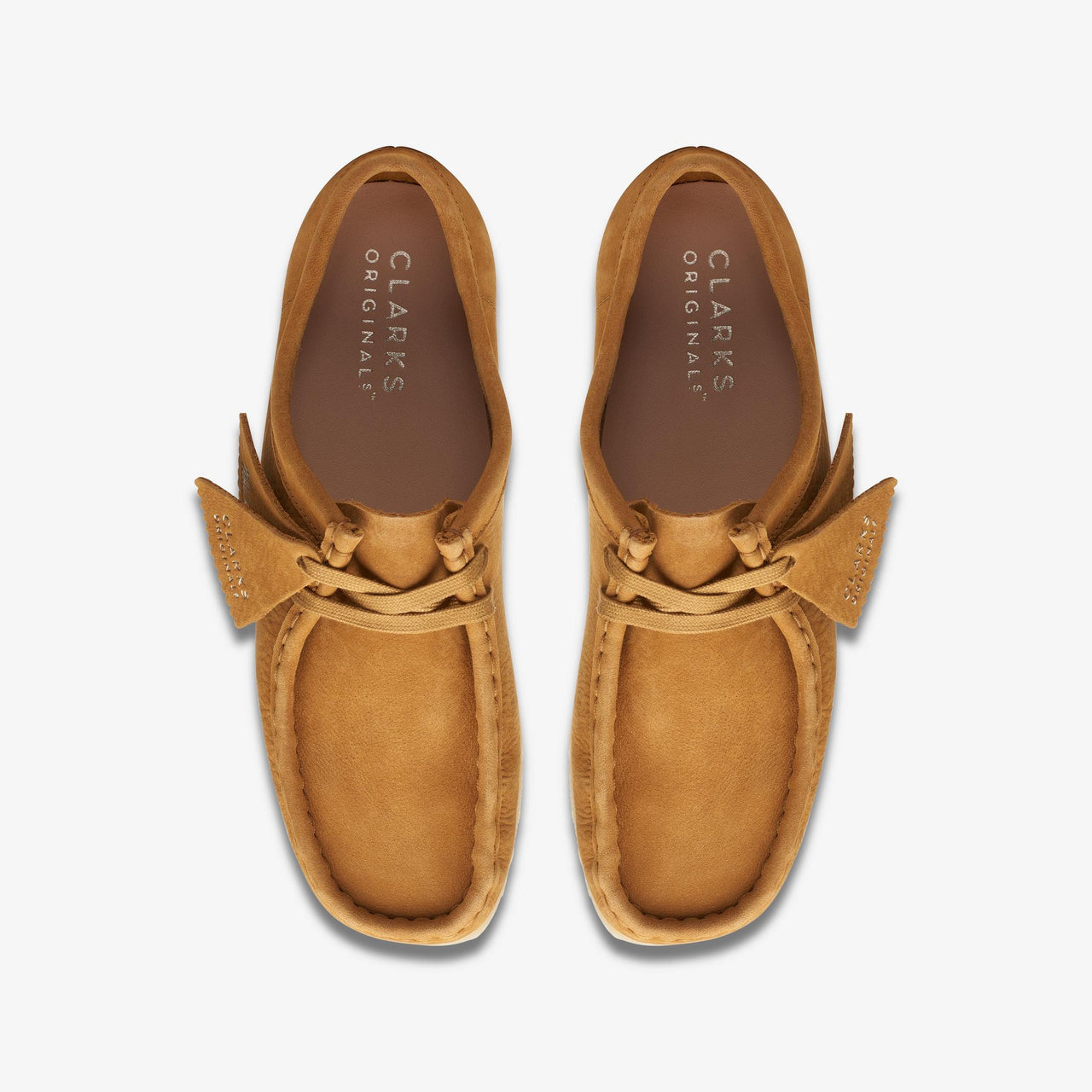 Pair of [26169923] Womens CLARKS WALLABEE - BROWN shoes in a natural setting, ideal for outdoor activities and everyday wear