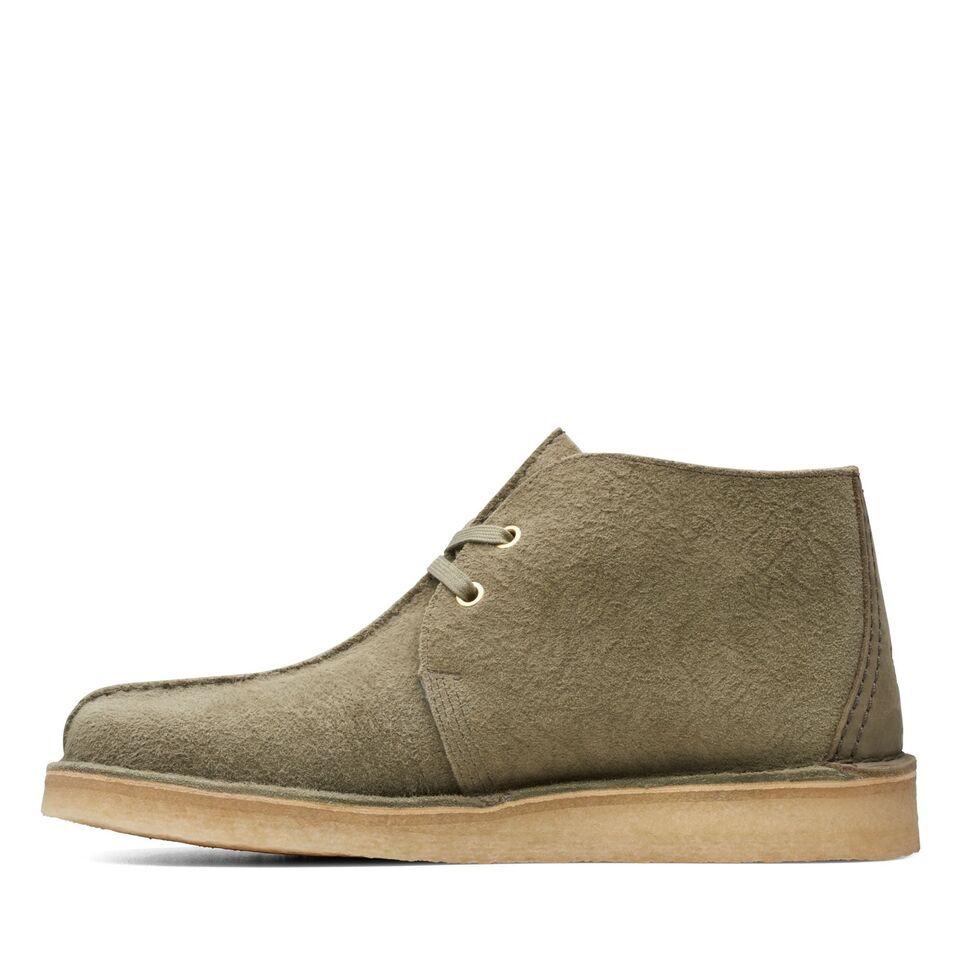  Man wearing Clarks Originals Desert Trek Hi 50 Men's Forest Green Suede 26173615 shoes while walking through a forest