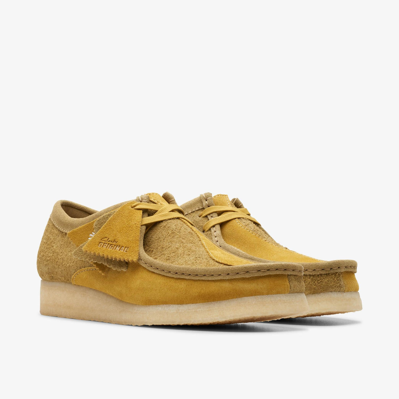 Pair of Men's CLARKS WALLABEE shoes in olive green on a wooden floor