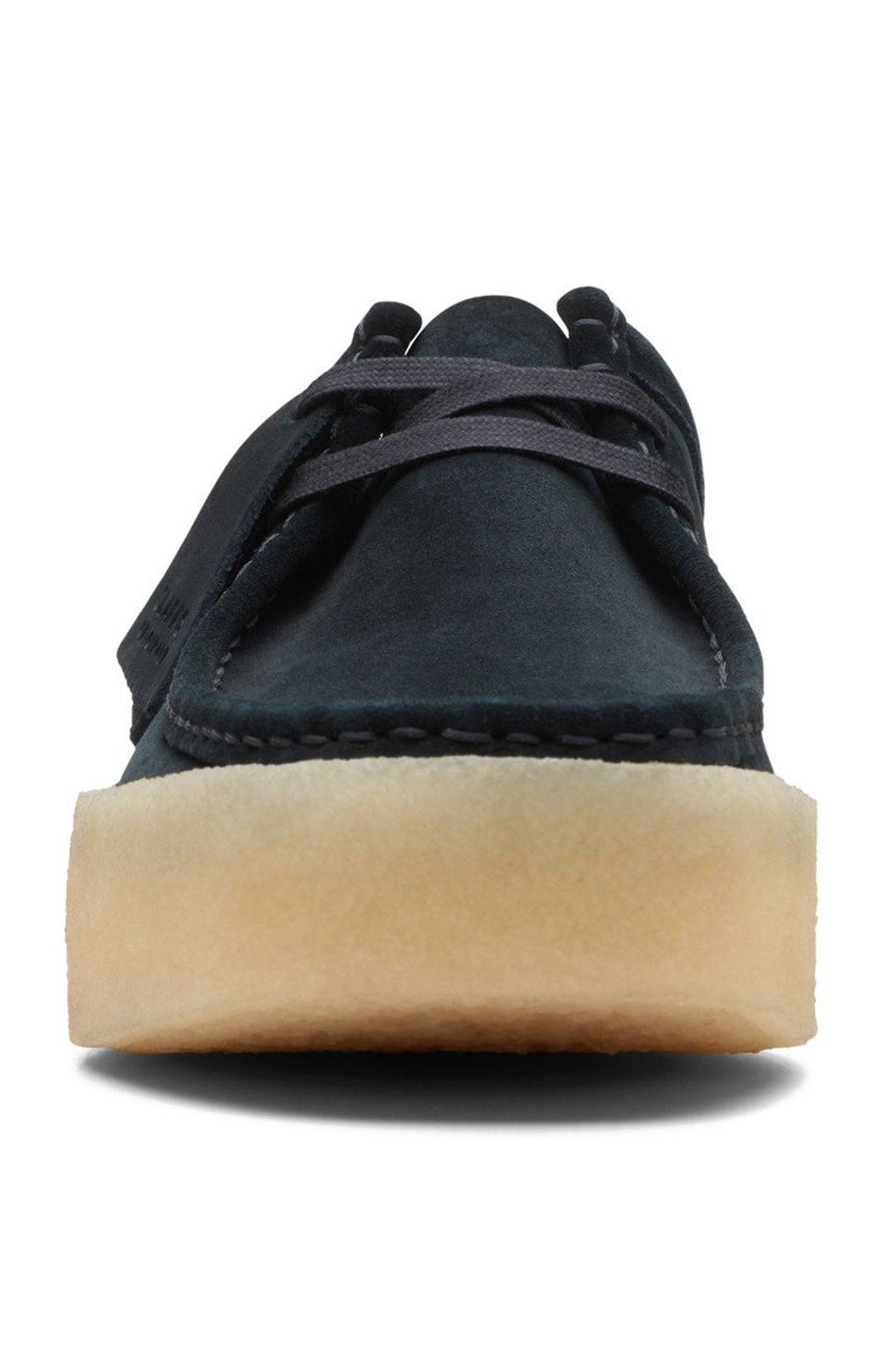 A man wearing the Clarks Originals Wallabee Cup Low Men's Black Suede 26167285 shoes while walking on a city sidewalk