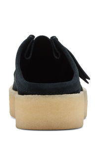 Thumbnail for A person holding the Clarks Originals Wallabee Cup Low Men's Black Suede 26167285 shoes to showcase their supple suede and classic design